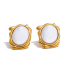 Gold-framed earrings with white stones on a white background